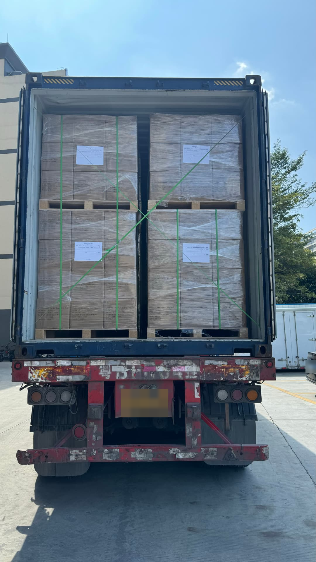 Container loading at our factory — palletized cartons stacked and strapped inside the container.