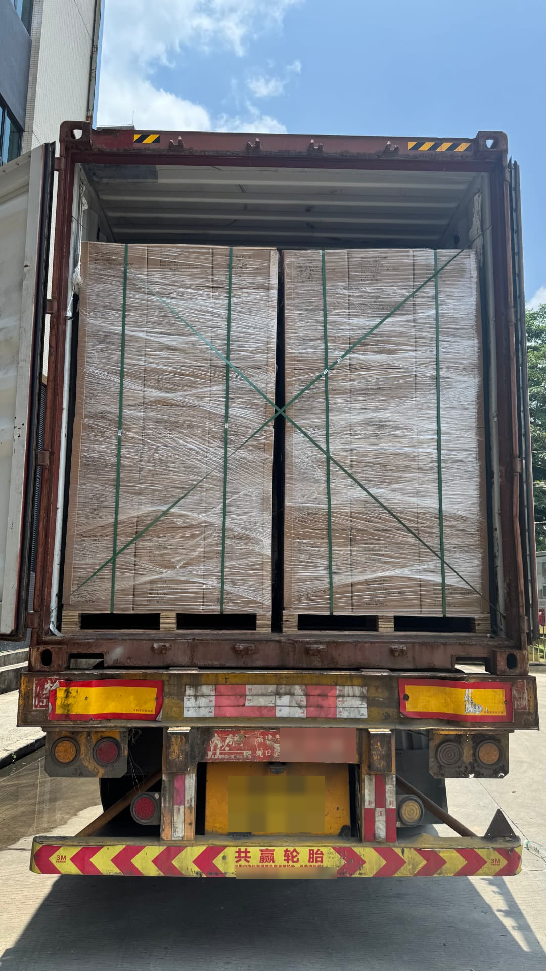 Wrapped pallets secured with straps before the container is closed.