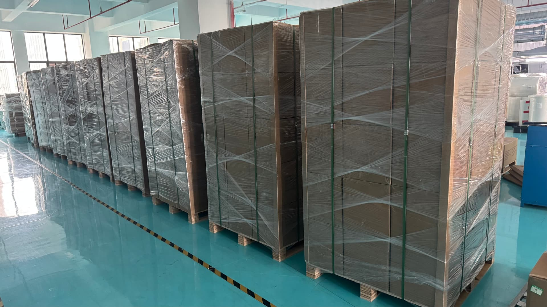 Finished goods palletized and staged inside the factory before loading.